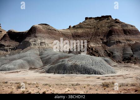 Arid rocky landscape with layered formations under a clear blue sky. USA Stock Photo
