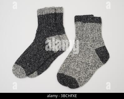 This image displays two pair of knitted wool socks in two shades of grey. The socks are thick and cozy, ideal for keeping warm during cold weather. On Stock Photo