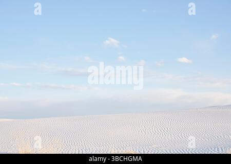 Vast desert landscape with rippled sand dunes under a clear blue sky. Road Trip USA Stock Photo