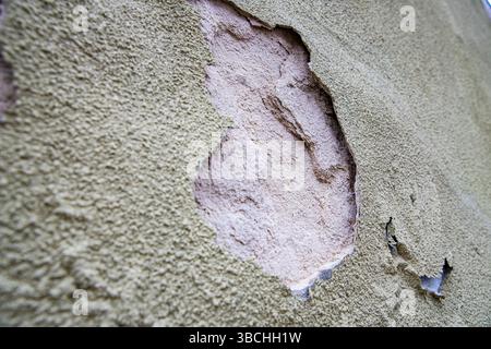 Old weathered brick wall with cracked plaster and peeling surface  Old weathered brick wall with cracked plaster and peeling surface Stock Photo