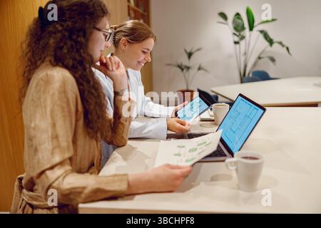 A Collaborative Workspace Featuring Laptops and Tablets for Enhanced Team Interactions Stock Photo