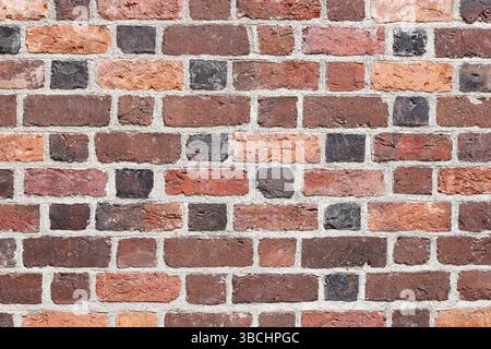 Red brick wall texture. Weathered surface background. Rustic architectural pattern. Old construction material. Horizontal masonry layout. Stock Photo