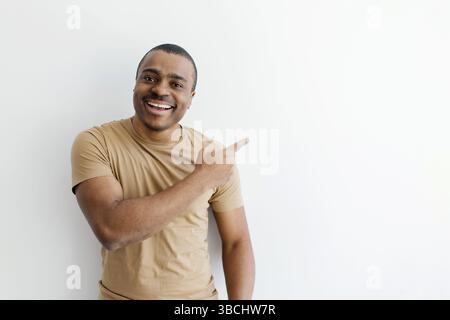 Smiling African American man pointing enthusiastically to the side Stock Photo