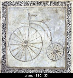 A path for bicycles is marked in concrete with the image of an old style penny-farthing bike Stock Photo