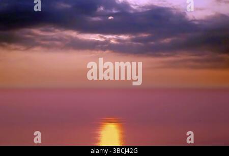 Dramatic sunset with dark clouds covering up part of sun over the Taiwan Strait Stock Photo