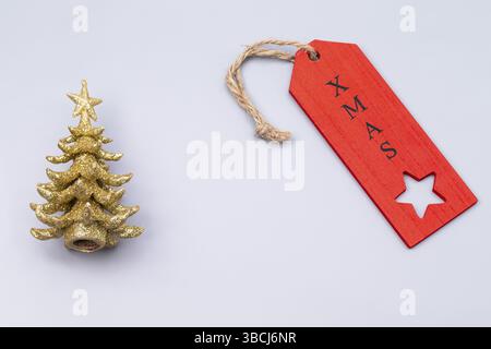 The photo shows a miniature golden Christmas tree against a grey background Stock Photo