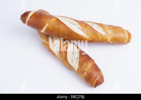 The photo shows several fresh pretzel sticks against a white background Stock Photo