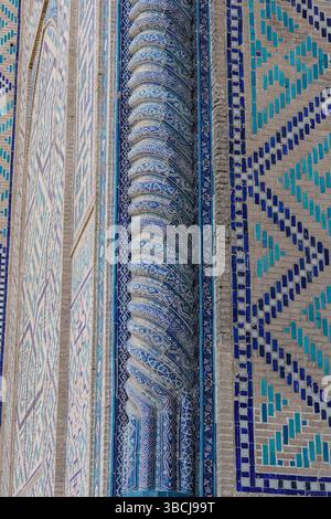 A close-up view of intricate blue and white tilework forms geometric patterns on a decorative wall at Bibi-Khanym Mosque in Samarkand, Uzbekistan. Stock Photo
