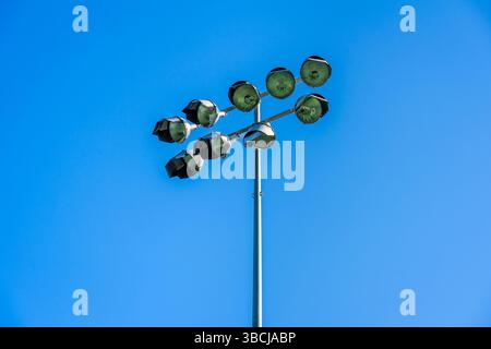 stadium floodlights on a post with a blue sky Stock Photo