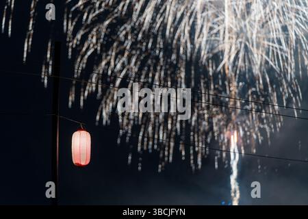Fireworks Display Over a Night Sky with a Japanese Lantern Stock Photo