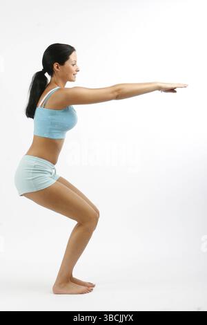 Young woman doing sports, squats, squat, cut out Stock Photo