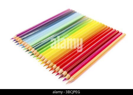 Various colored crayons lying side by side in a square isolated on white background Stock Photo