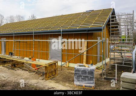 Construction phase of a modern single story eco friendly timber framed house, roof structure and wall framework Stock Photo