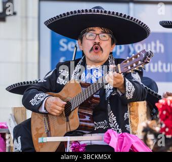 A man wearing a sombrero, playing the guitar, and singing at the Victoria Day Parade on May 19, 2025 in Victoria, British Columbia, Canada. Stock Photo