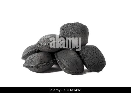 A heap of several charcoal bricks stacked on to a white background Stock Photo
