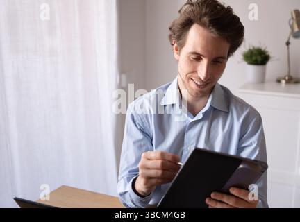 Remote work scene with businessman using technology and managing his time Stock Photo