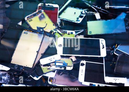 Pile of old broken smartphone phones with broken touch screen. Stock Photo