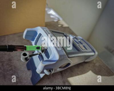 Optical power meter measuring light level of fiber optic cable during maintenance work Stock Photo