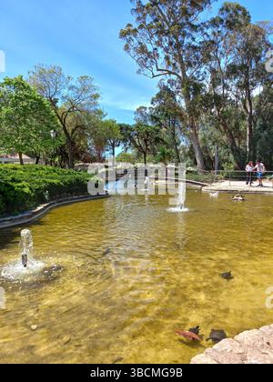 Cascais Portugal May 1 2025 People enjoying leisure time in city park featuring grassy areas benches and shaded walkways on a clear day Stock Photo