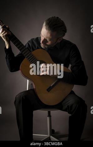 Portrait of a guitarist playing in a studio Stock Photo