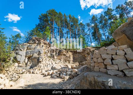 Limestone blocks. Quarry surrounded by forest. Rocky cliff. Jozefow, Roztocze region, Poland. Lublin Voivodeship Stock Photo