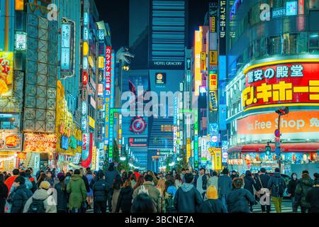 High-resolution photo capturing the bustling nightlife of Shinjuku, Tokyo, Japan. The image features glowing neon signs, busy streets, and the dynamic Stock Photo