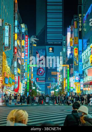 High-resolution photo capturing the bustling nightlife of Shinjuku, Tokyo, Japan. The image features glowing neon signs, busy streets, and the dynamic Stock Photo