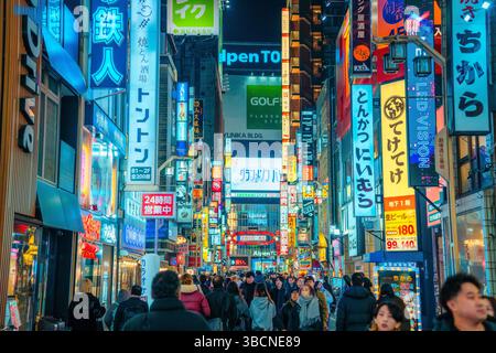 High-resolution photo capturing the bustling nightlife of Shinjuku, Tokyo, Japan. The image features glowing neon signs, busy streets, and the dynamic Stock Photo