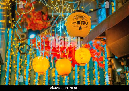 High-resolution photo capturing the bustling nightlife of Shinjuku, Tokyo, Japan. The image features glowing neon signs, busy streets, and the dynamic Stock Photo