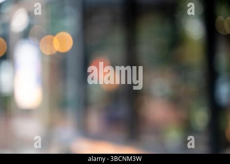 A blur cafe coffee with bokeh background image shows out of focus scene with warm and cool light spots, creating soft, abstract background that Stock Photo