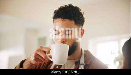Man, chef and drinking coffee in kitchen for morning beverage, break or caffeine at home. Male person, relax and enjoying espresso with mug or cup for Stock Photo