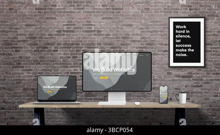 Responsive web design concept displayed on desktop, laptop, and smartphone, with ‘We build websites’ headline and brick wall background Stock Photo