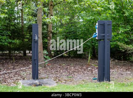 A water tap and electric hook up point in a forest campsite Stock Photo