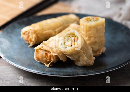 Crispy Spring Rolls on Ceramic Plate on wooden table Stock Photo