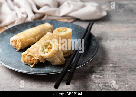 Crispy Spring Rolls on Ceramic Plate on wooden table Stock Photo