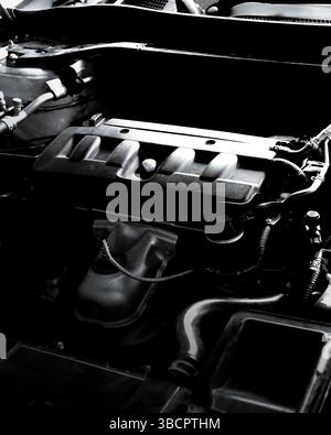 Car Engine Monochrome, Close-up, monochrome shot of a car engine bay showing the motor, hoses, and various mechanical components. Stock Photo