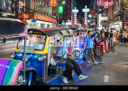 People and Tuk Tuk Taxi at Night Streetmarket on Yaowarat Road in Chinatown in City of Bangkok in Thailand.  Thailand, Bangkok, November, 4, 2024. Stock Photo