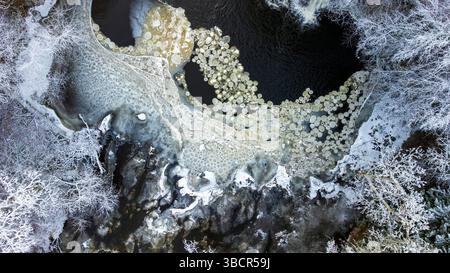 Aerial view of rare ice pancake formations on the River Cart in Linn Park, Glasgow, Scotland — a striking winter phenomenon shaped by freezing current Stock Photo