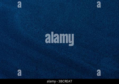 Fine-grain dark blue sand texture with subtle gradients, ideal for backgrounds and design overlays. Stock Photo