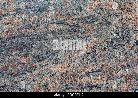High-resolution close-up of multicolored polished granite with natural speckled patterns, ideal for design, architecture, and backgrounds. Stock Photo
