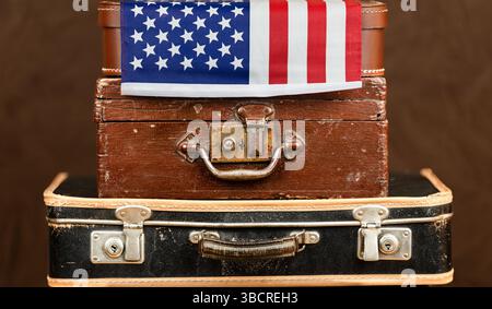 Old luggages with American government flag. US citizenship, immigration background. Stock Photo