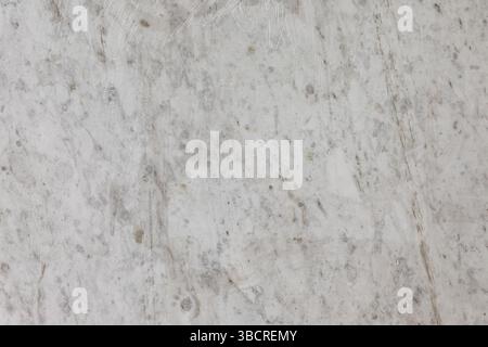 Close-up of a light gray marble surface with scratches and natural veining, perfect for backgrounds, architecture, or design mockups Stock Photo
