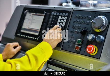 Close up Machine operator hand turns on control panel of industrial machine. technician push button on control pannel Stock Photo