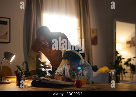 Assisting Child with Homework in Cozy Home Environment Stock Photo