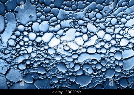Blue abstract fluid pattern. Oil bubbles in water. Macro texture background. Futuristic scientific look. Liquid circles overlap. Molecular biology. Stock Photo