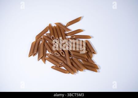 Wholewheat  Penne pasta on a white background, dried Stock Photo