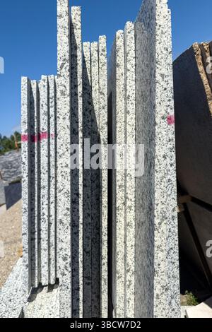 Granite slabs vertically arranged outdoors, showing industrial texture and saw marks. Editorial use only, no people. Stock Photo