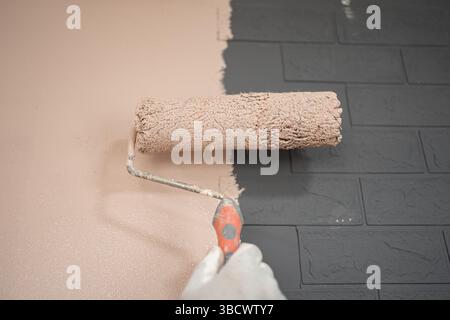 Person Using Roller to Paint Wall Stock Photo