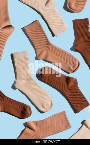 Collection of ribbed socks in shades of beige, brown, and cream is displayed on light blue background, highlighting their unique textures and colors f Stock Photo