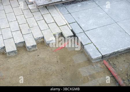 paver installation in progress with flexible work tubs, preparing ground for garden paver pathway construction Stock Photo
